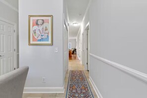 A hallway with a patterned rug, a framed artwork on the wall, and a door at the end. - 2BR 2Bath Intracoastal waterfront condo in golf course community Dog friendly!  (Myrtle Beach)