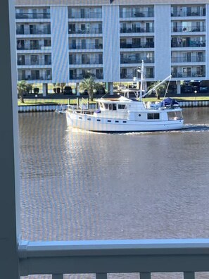 A boat on a body of water with a multi-story building in the background. - 2BR 2Bath Intracoastal waterfront condo in golf course community Dog friendly!  (Myrtle Beach)