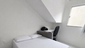 A bedroom with a bed, a desk, and a chair. - Beach house in Jacuípe | Bahia coast | 4 bedrooms | Pool and gourmet area (Camaçari)