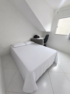 A bedroom with a bed, a desk, and a chair. - Beach house in Jacuípe | Bahia coast | 4 bedrooms | Pool and gourmet area (Camaçari)