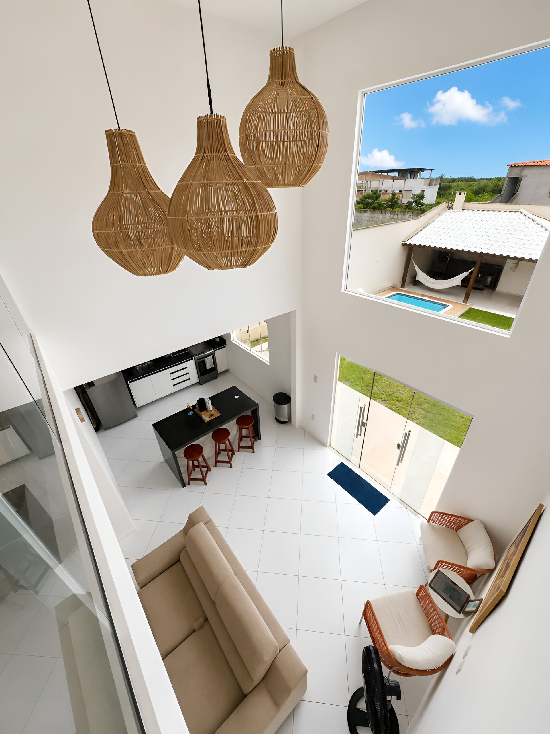 A modern interior with a kitchen, dining area, and a balcony with a pool.
