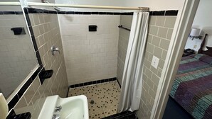 Un baño con ducha, lavamanos e inodoro.