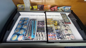 Un congelador con diversos postres y refrigerios congelados.
