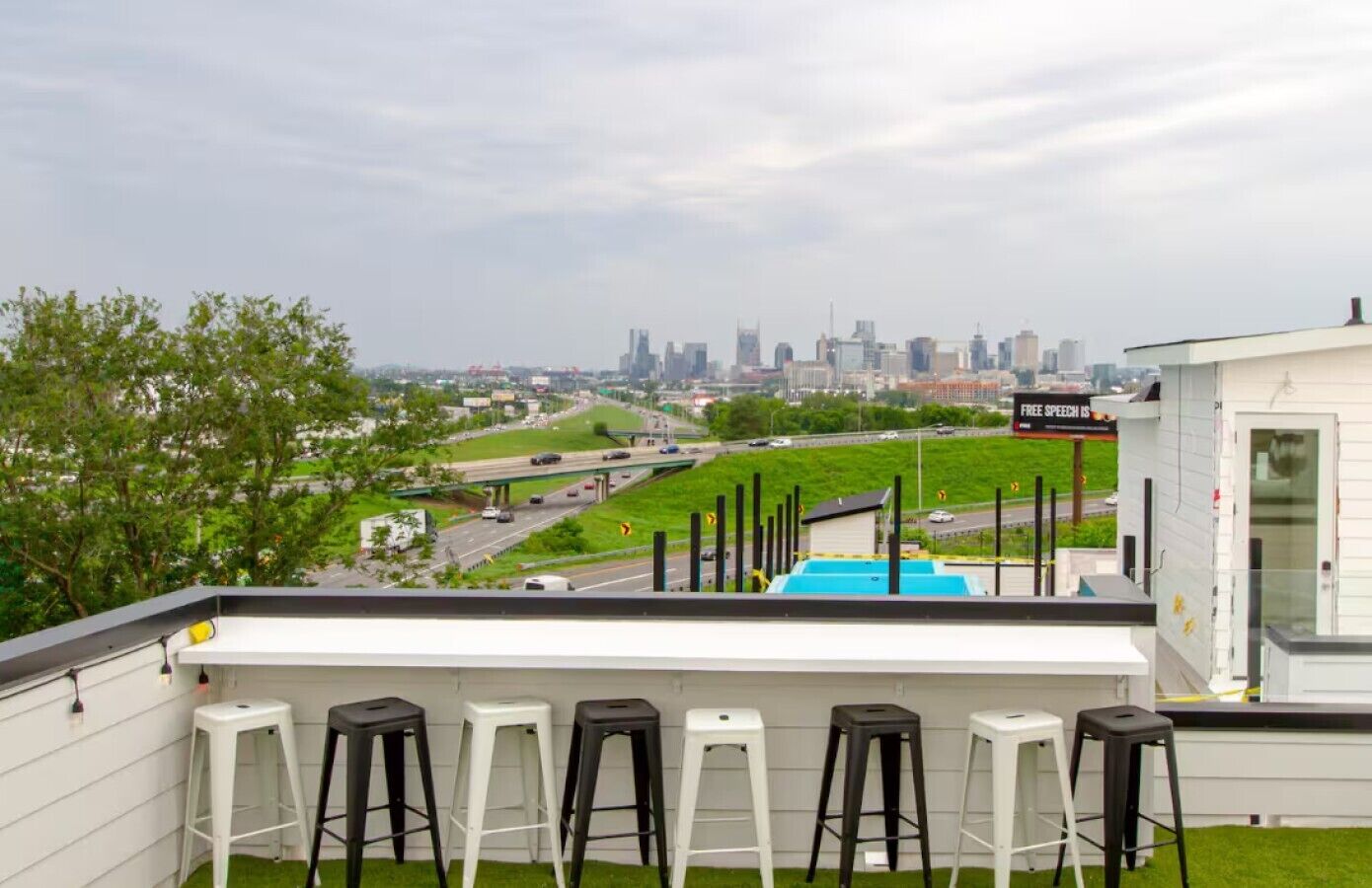 Rooftop bar seating area with panoramic downtown Nashville skyline views.
