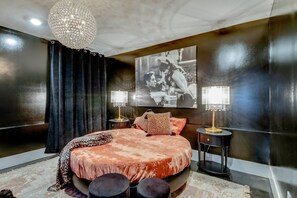 Sophisticated bedroom design complete with plush seating, rich dark wall finishes, and hotel-quality linens. - The Playmate - a Glam Rooftop Retreat with Hot Tub, Putting Green & Skyline View (Nashville)