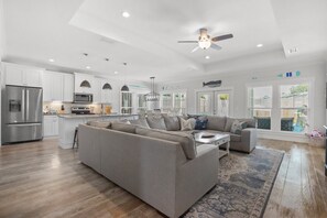 A modern kitchen with white cabinets, a stainless steel refrigerator, and a built-in microwave. - Caribbean Surf | Private Pool | Beach Access | PCB | Near Beach (Panama City Beach)