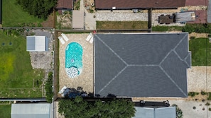 An aerial view of a residential area with a swimming pool, a large covered patio, and a house with a sloped roof. - Caribbean Surf | Private Pool | Beach Access | PCB | Near Beach (Panama City Beach)