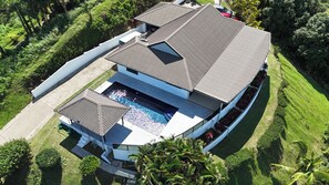 A modern house with a swimming pool, a covered patio, and a well-maintained lawn. - Seawinds Aura :House with spectacular ocean views and enormous balcony (Maui Bay, Coral Coast)