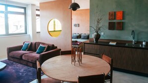 Un espacio habitable moderno con una mesa de comedor redonda, un sofá y una zona de cocina.