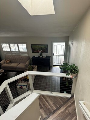 A spacious living area with a high ceiling, a sofa, a coffee table, and a painting on the wall. - Serene 4-bedroom house in San Diego perfect for your getaway (San Diego)