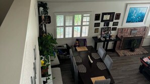 Ein Essbereich mit Tisch und Stühlen, einem Kamin und einem großen Fenster.