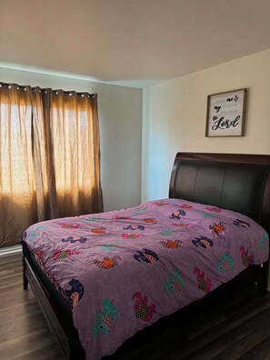 A bedroom with a bed, a headboard, a window with curtains, and a wall-mounted sign. - Serene 4-bedroom house in San Diego perfect for your getaway (San Diego)
