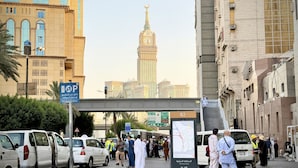 Uma rua movimentada na cidade, com uma torre imponente ao fundo.