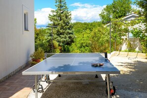 A ping pong table in an outdoor setting with a house in the background. - Villa Ester (Istria - Loborika) (Loborika)