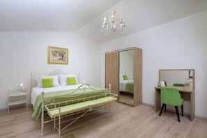 A bedroom with a bed, bedside table, chair, desk, mirror, and a chandelier. - Villa Marija Pekici (Istria - Svetvinčenat) (Svetvinčenat)