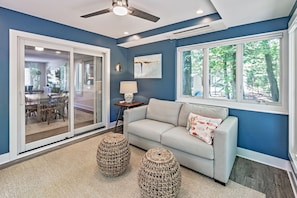 A living room with a sofa, two woven ottomans, a lamp, and a ceiling fan. - Walk to the Beach and Boardwalk, Sleeps 13, Pool: Newly Renovated (Bethany Beach)