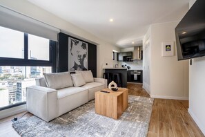 A modern apartment with a living room, kitchen, and large windows. - San Isidro Lux Studio Apartment (San Isidro)