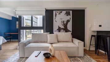 Una sala de estar moderna con un sofá, una mesa de centro y una obra de arte abstracta de gran tamaño en la pared.