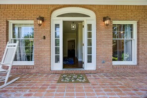 A brick house with a front porch, two windows, and a door. - Waterfront Amelia Island home with amazing views, deck, parking. (Fernandina Beach)