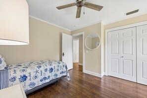 A bedroom with a bed, a ceiling fan, a door, and a hallway. - Waterfront Amelia Island home with amazing views, deck, parking. (Fernandina Beach)