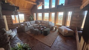 Un amplio espacio de sala con un gran sofá, una mesa de centro y una chimenea.