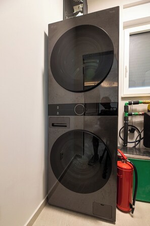 A compact, modern kitchen with a built-in washer and dryer, a window, and a red fire extinguisher. - Villa Azoria with pool and jacuzzi (Kvarner - Žgaljići) (Žgaljići)