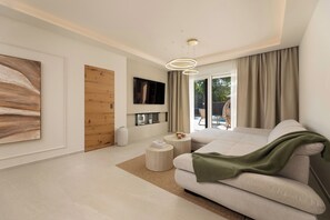 A modern living room with a sofa, a TV, a wooden door, and a view of the outdoors. - Villa Azoria with pool and jacuzzi (Kvarner - Žgaljići) (Žgaljići)