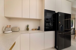 A modern kitchen with a black refrigerator, a coffee maker, and a toaster on the counter. - Villa Azoria with pool and jacuzzi (Kvarner - Žgaljići) (Žgaljići)