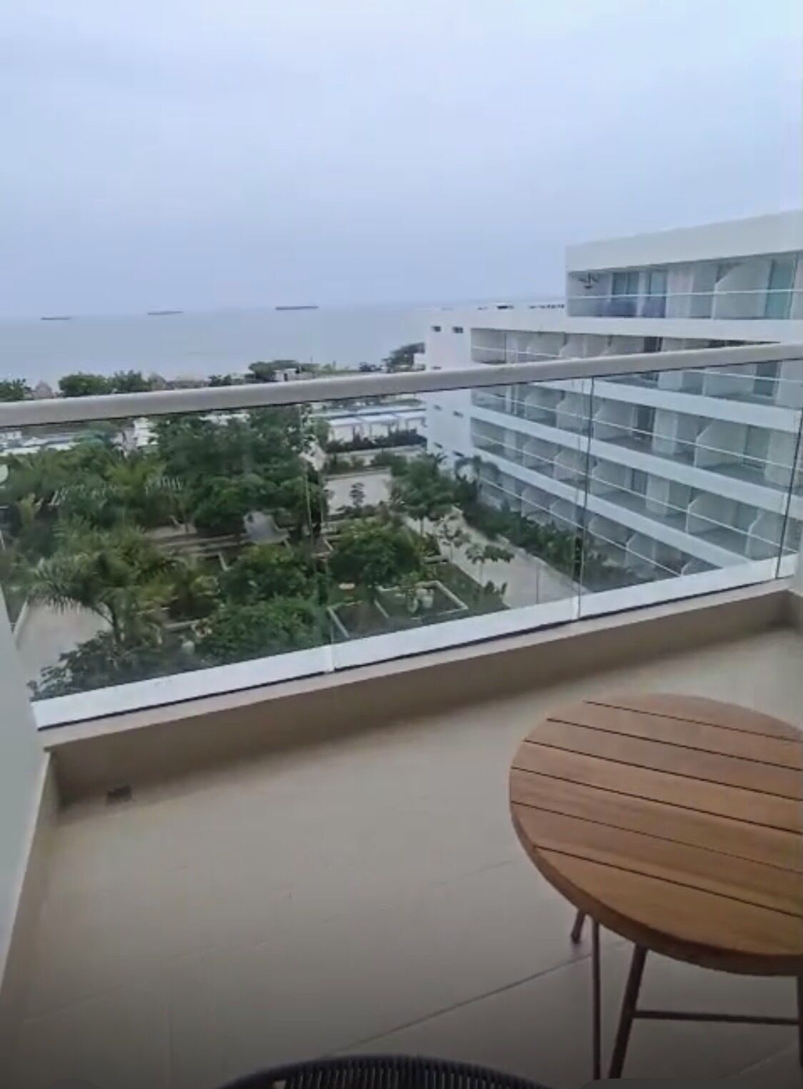 A balcony with a view of a residential area and a body of water.