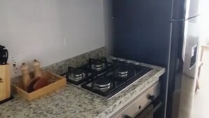 A kitchen with a gas stove, oven, and a black refrigerator. - Santa Marta apartment ocean view 579 a (Santa marta)