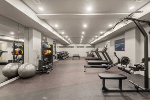 A modern gym with treadmills, weight machines, and exercise balls. - Penthouse Combo | Pool, Views, Near Broadway (Nashville)