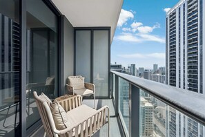 A balcony with two chairs and a glass railing overlooking a cityscape. - Sky Spritz  Downtown, Pool, Gym, Full Service Tower (Miami)