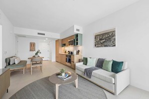 A modern living room with a sofa, coffee table, and a dining area with a table and chairs. - Sky Spritz Downtown Miami, Pool, Gym, Amenities (Miami)