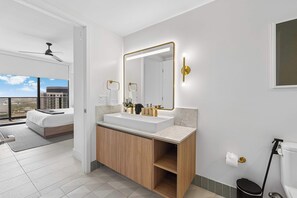 Ein modernes Badezimmer mit großem Spiegel, Waschbecken und Toilette.
