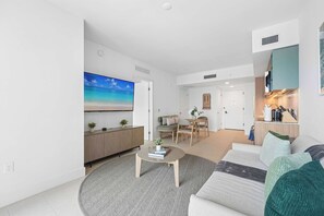 A modern living room with a flat-screen TV, a coffee table, a sofa, and a dining area with a table and chairs. - Sky Spritz Downtown Miami, Pool, Gym, Amenities (Miami)