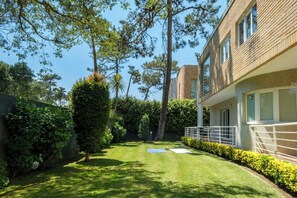 A well-maintained garden with a lawn, hedges, and trees. - Casa das Andorinhas by Hommelier (Fão)