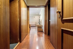 A wooden hallway leading to a living area with a sofa and a small table. - Casa das Andorinhas by Hommelier (Fão)