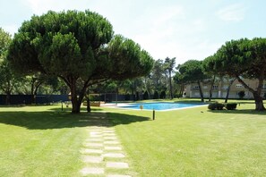 A swimming pool surrounded by grass, trees, and a building in the background. - Casa das Andorinhas by Hommelier (Fão)