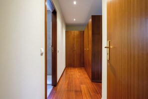 A hallway with wooden flooring and doors, leading to a room. - Casa das Andorinhas by Hommelier (Fão)