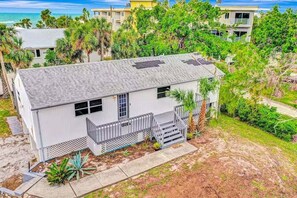 A single-story house with a grey roof, a small porch, and a fenced yard. - Newly Renovated Beach Retreat Just Steps from Englewood Beach - Beach Barracks - Roelens (Englewood)