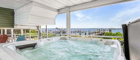 Un jacuzzi con vistas a un muelle y al agua.
