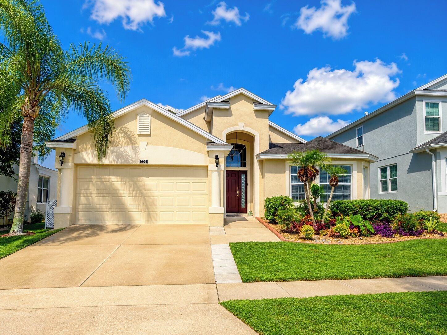 A residential house with a garage, a front door, and a well-maintained lawn.