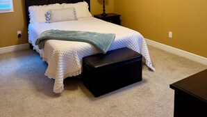 A bedroom with a bed, a nightstand, a lamp, a ceiling fan, and a window with blinds. - Charming 2-bedroom condo on Lake Hamilton (Hot Springs)