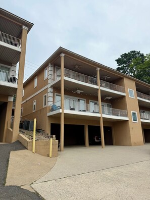 A multi-story residential building with balconies, a central courtyard, and a parking area. - Charming 2-bedroom condo on Lake Hamilton (Hot Springs)