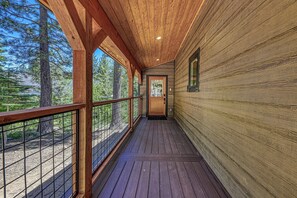 A wooden corridor with a metal railing, leading to a door with a window. - Dreamcôte Chalet in Ward Canyon by Tahoe Getaways - Pet-Friendly 4BR w Sauna & A/C (Tahoe City)