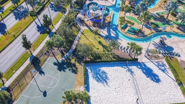 Vista aérea de uma área de lazer com quadra de basquete, piscina e toboágua.