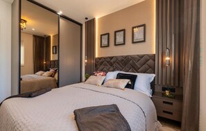 A hotel room with a large bed, a mirror, a headboard, and framed artwork on the wall. - Nice apartment in Makarska with lake view (Makarska)