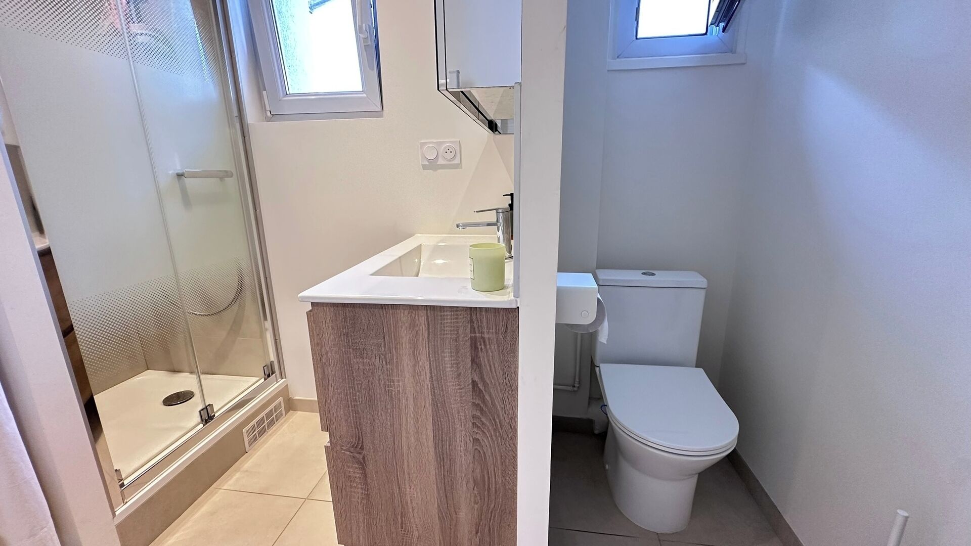 Et badeværelse med bruser, toilet og vask.