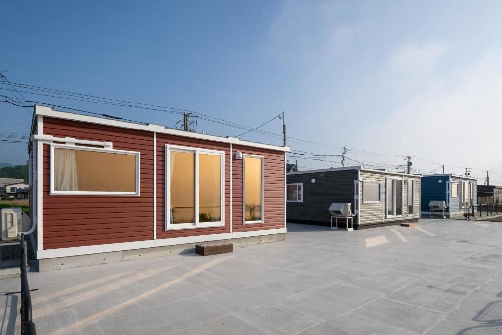 A row of mobile homes with a flat roof and a paved ground.