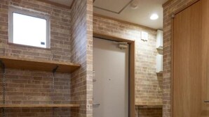 Una habitación con paredes de ladrillo, suelo de madera y estanterías empotradas.